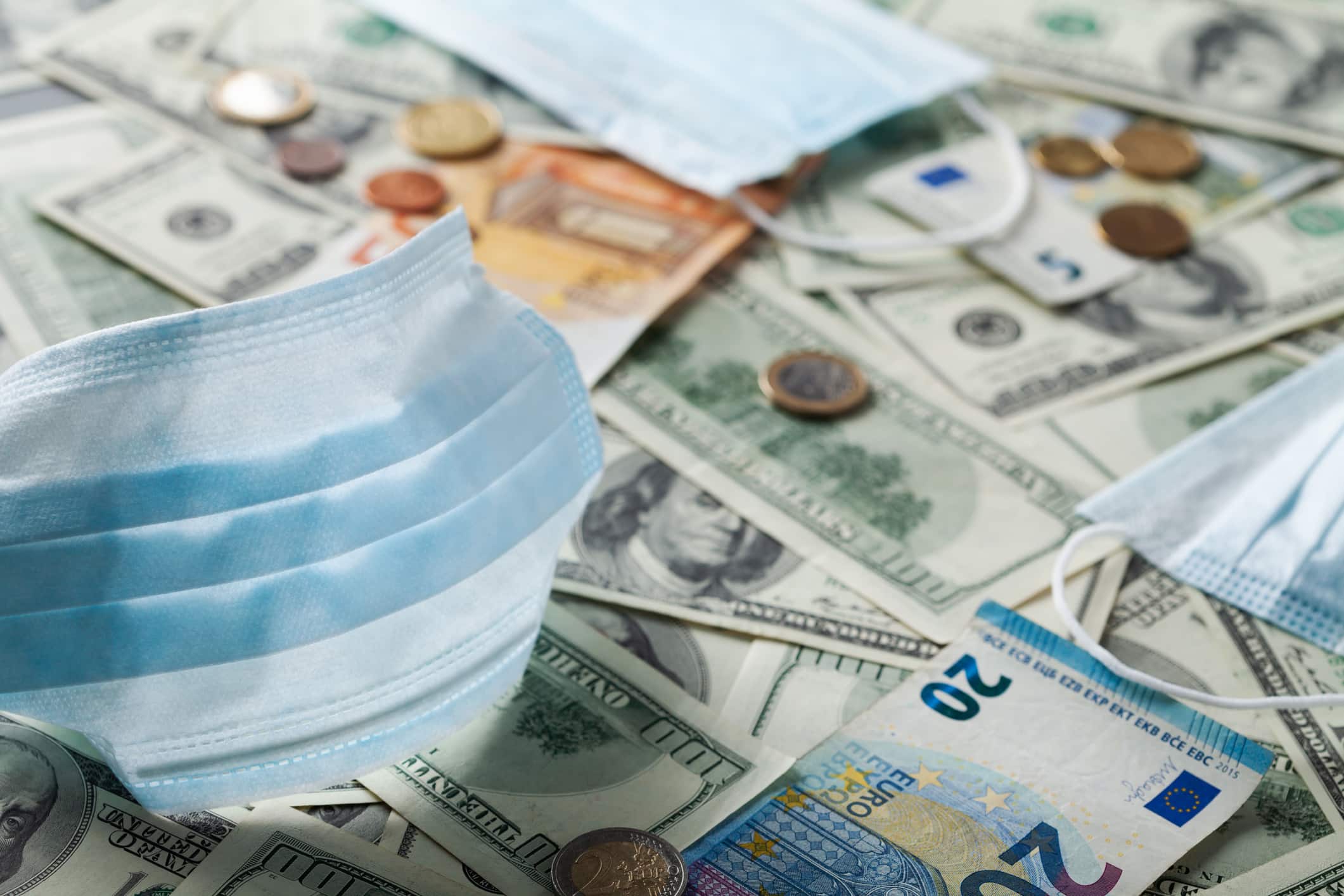 Medical face mask and money, world coronavirus epidemic and economic losses and damage concept.